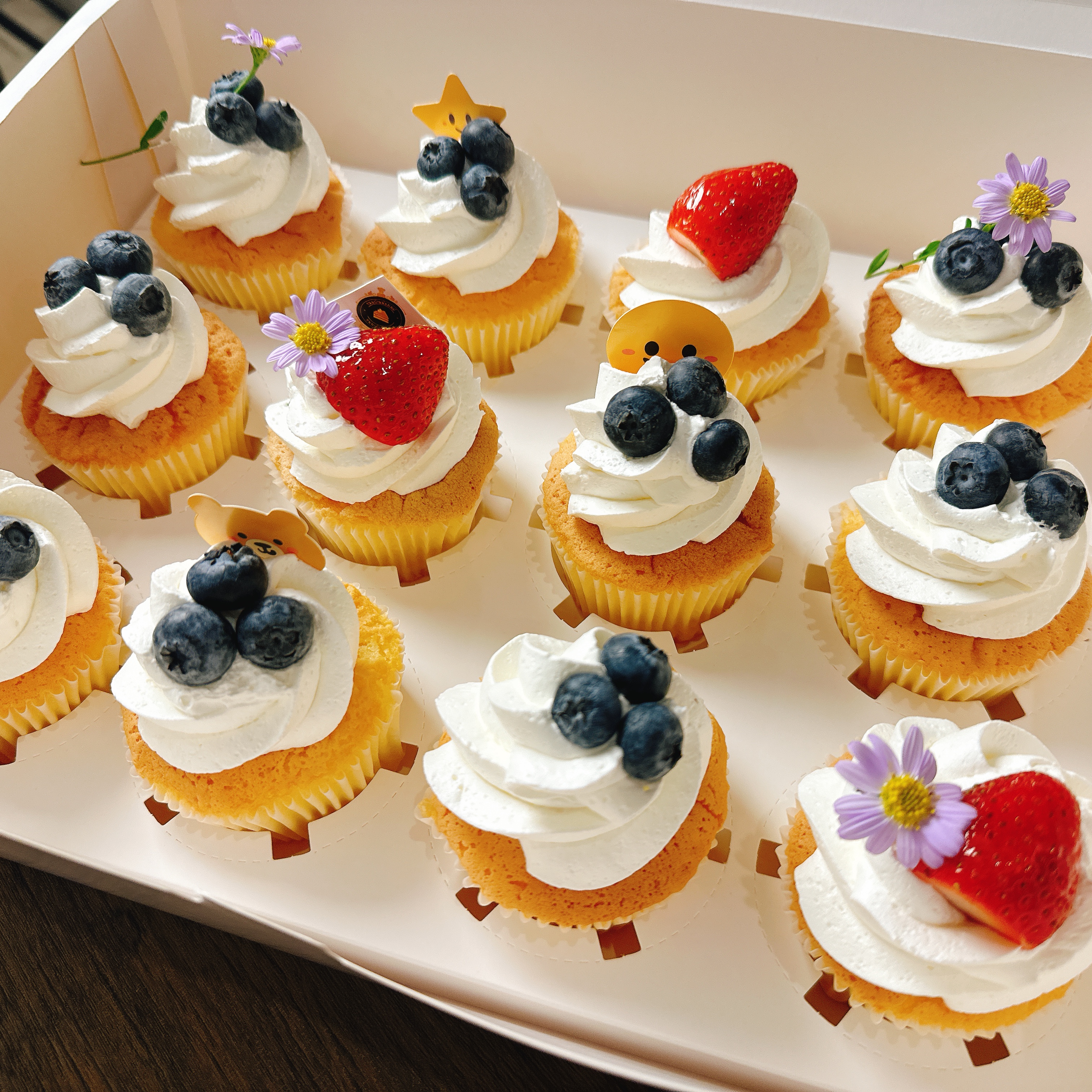 คัพเค้กวนิลาครีมสด ตกแต่งด้วยผลไม้สดและดอกไม้ทานได้ กล่องละ 12ชิ้น