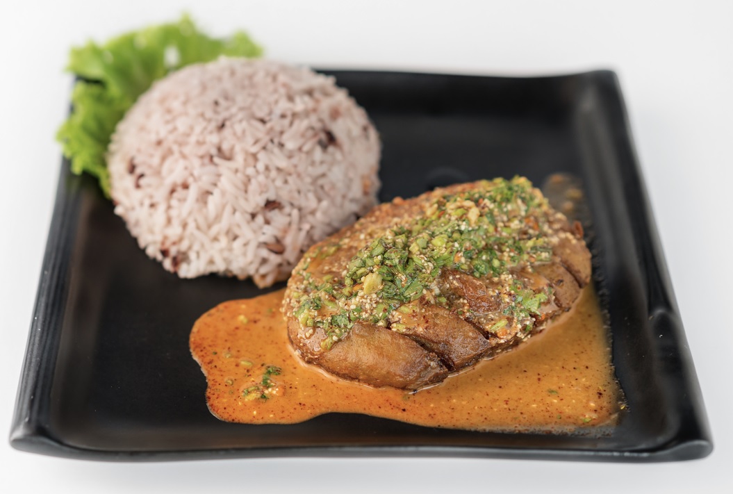 ข้าวไก่ย่างน้ำตก ใส่ในจานสีดำ ของร้านโซวีแกน