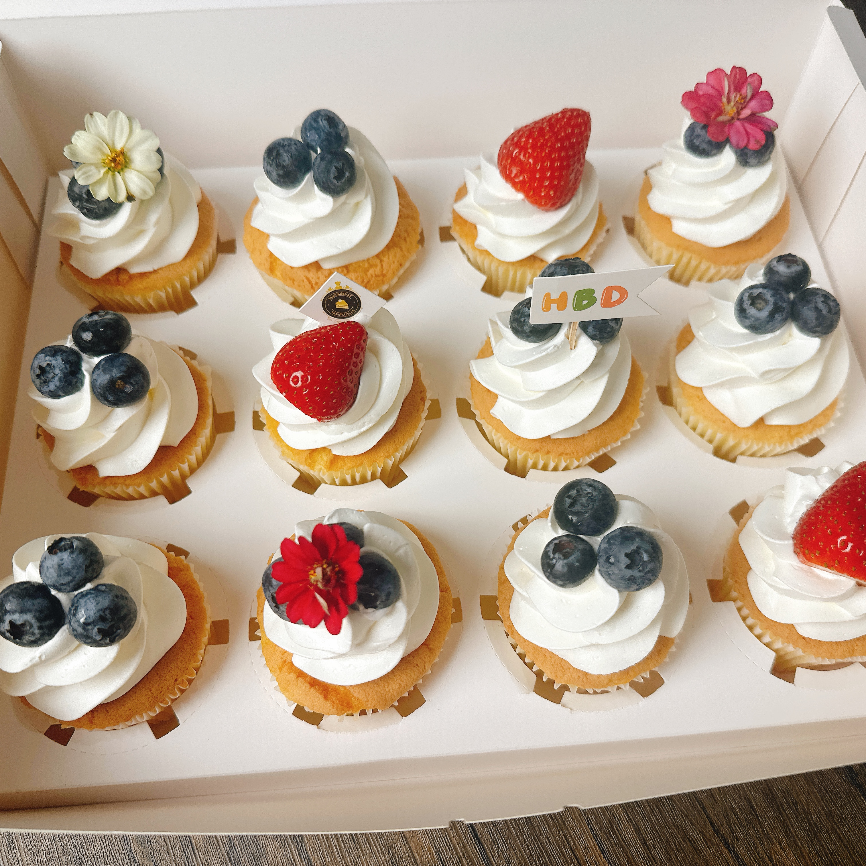 คัพเค้กวนิลาครีมสด ตกแต่งด้วยผลไม้สดและดอกไม้ทานได้ กล่องละ 12ชิ้น