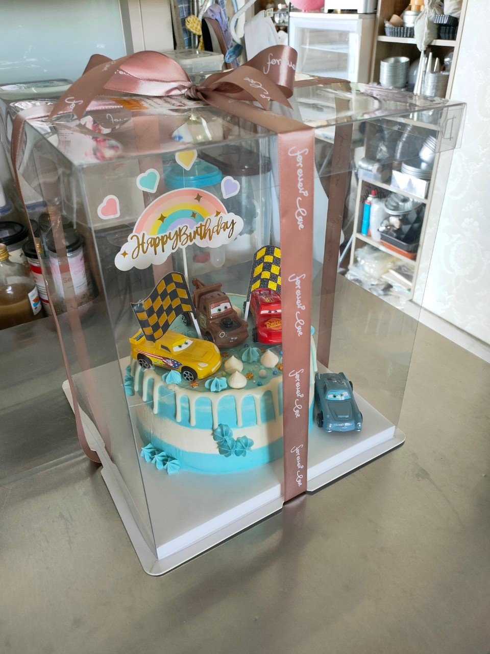 เค้กวนิลาตกแต่งด้วยบัตเตอร์ครีมและดิปชอคโกแลต วางตกแต่งด้วยโมเดลรถยนต์ด้านบน ขนาด2ปอนด์