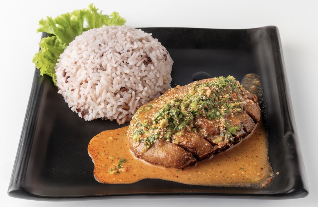 ข้าวไก่ย่างน้ำตกเจ ใส่ในจานสีดำ ของร้านโซวีแกน