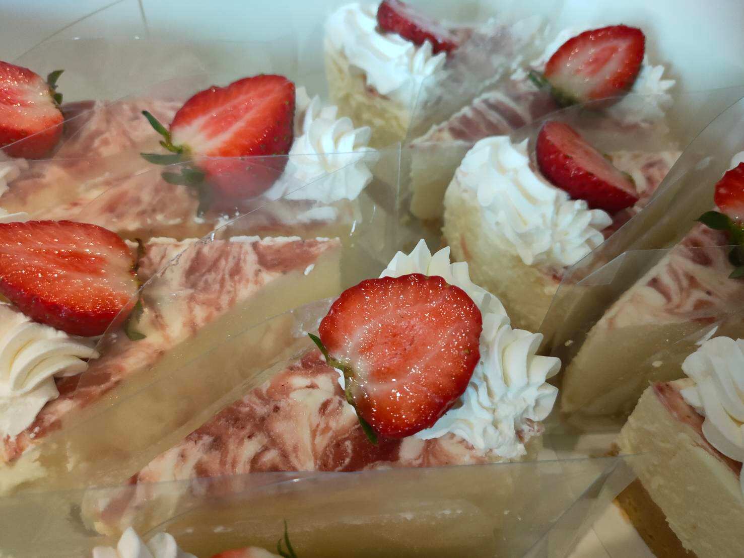 สตอเบอร์รี่ชีสเค้ก รองฐานด้วยแครกเกอร์ ด้านบนทำด้วยครีมชีส ตกแต่งด้วยซอสสตอเบอร์รี่และสตอเบอร์รี่สด