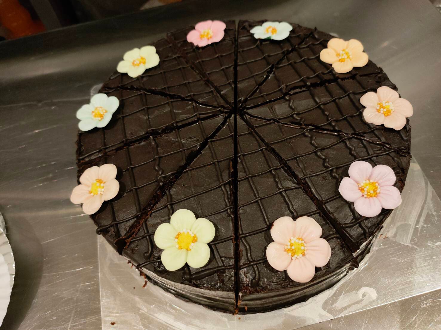 คริสมาสต์ชอคโกแลตเค้ก บัตเตอร์เค้กรสชอคโกแลต เคลือบด้วยครีมรสชอคโกแลตเข้มข้น และตกแต่งด้วยดอกไม้สวยงาม