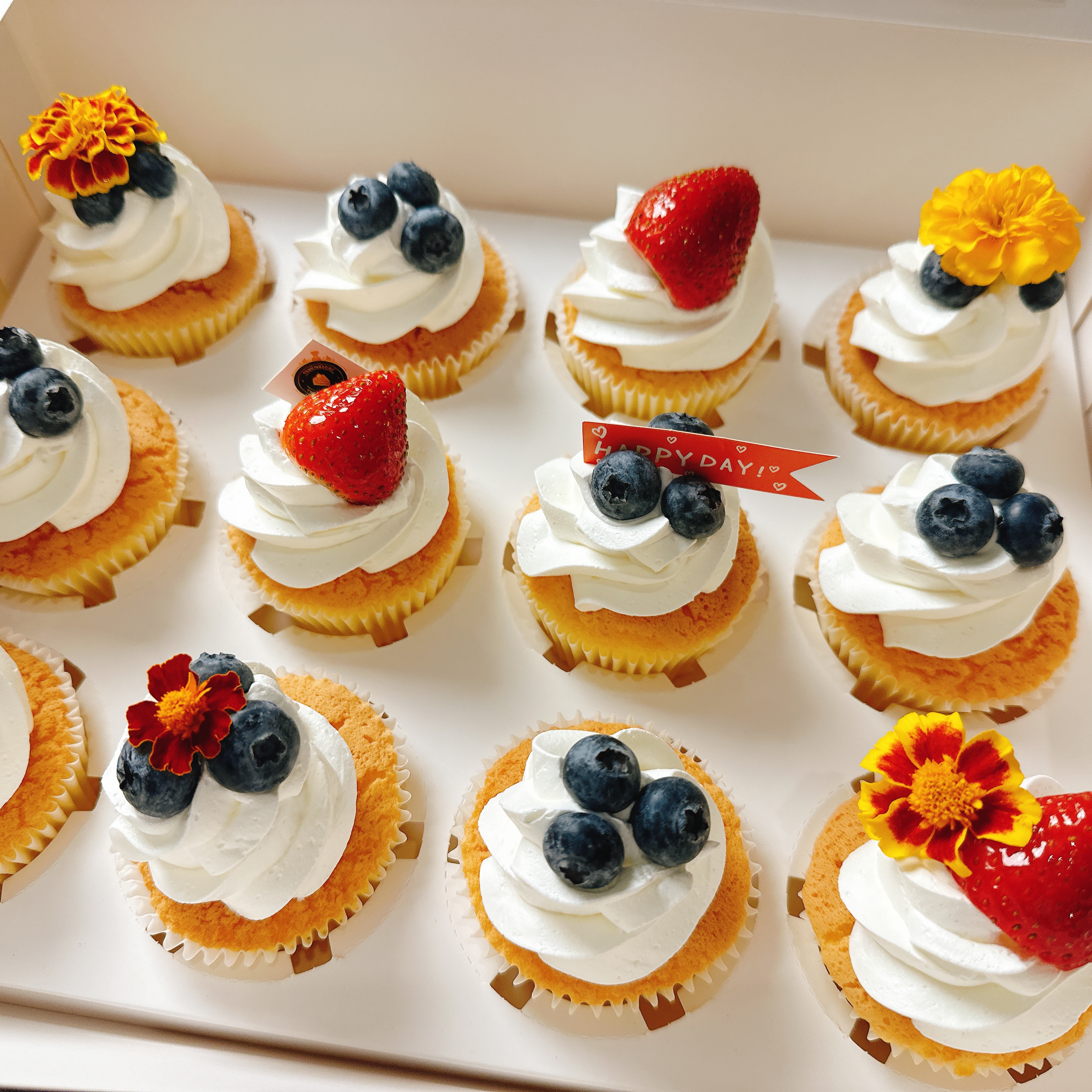 คัพเค้กวนิลาครีมสด ตกแต่งด้วยผลไม้สดและดอกไม้ทานได้ กล่องละ 12ชิ้น