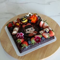 บราวนี่หน้าฟิมล์ทำจากเนยสดแท้ ตกแต่งด้วยขนมชอคโกแลตและสตอเบอร์รี่ ดอกไม้ทานได้ ขนาดประมาณ 1ปอนด์